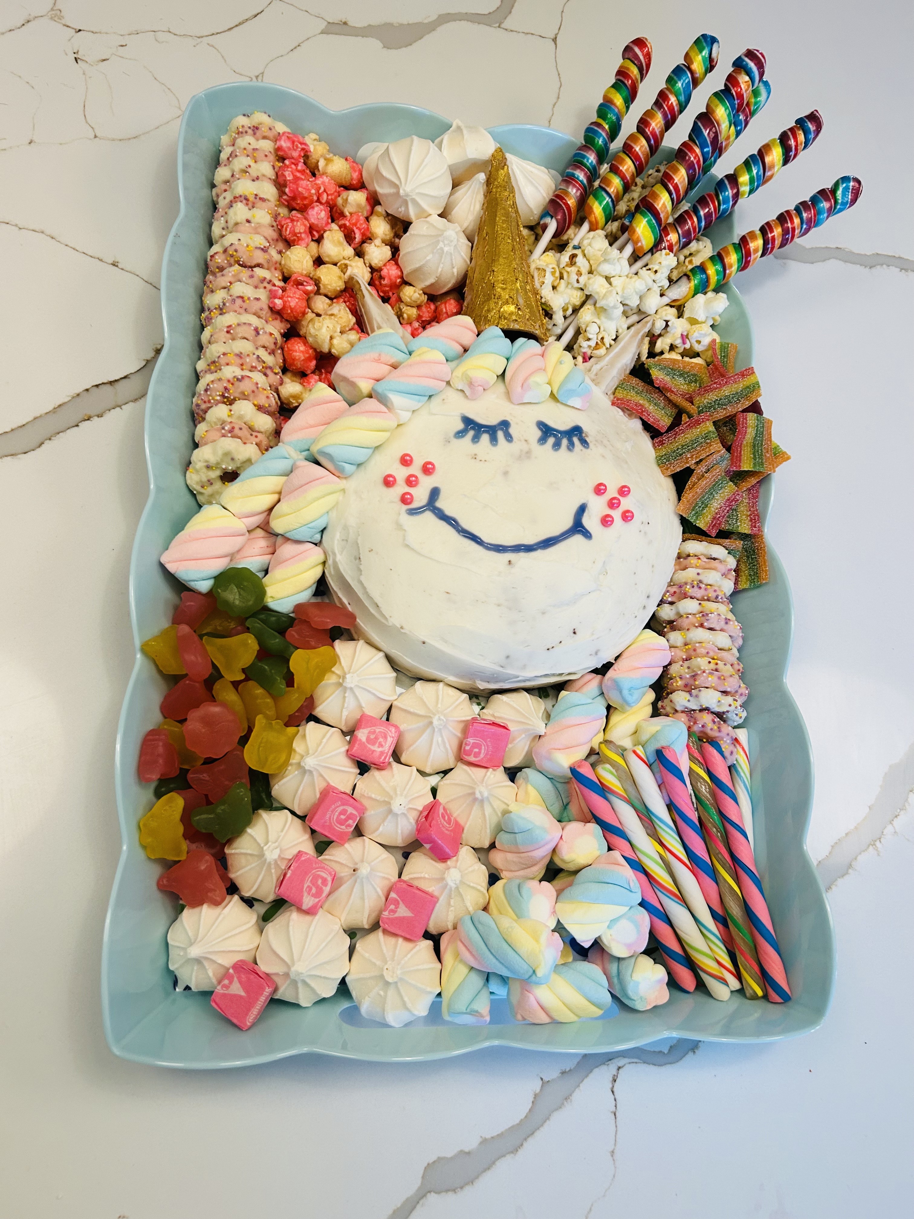Colorful dessert board with unicorn cake and candies
